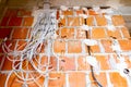 Pile of cables is hanging from a fuse box placed on the wall of unfinished building Royalty Free Stock Photo
