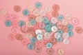 Pile of candy button for sewing on pink background