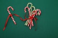 Pile Caramel sugar canes tied with a red ribbon on a green background. Christmas background. Concept of Christmas and New Year.