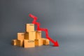 A pile of cardboard boxes and a red arrow down. The decline in the production of goods and products, the economic downturn Royalty Free Stock Photo