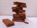 pile of chocolate biscuit cakes sprinkled with sugar on a white table
