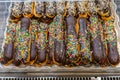 Pile of choux sticks with chocolate and colorful sweet sprinkles Royalty Free Stock Photo