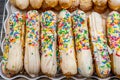 Pile of choux sticks pastry topped with colorful candy sprinkles Royalty Free Stock Photo