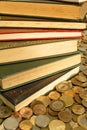 Pile of classics books surrounded with coins. The currency of the money is Brazilian Real