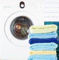Pile of clean towels with washing machine Royalty Free Stock Photo