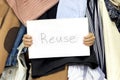 Pile of cloth with Reuse table sign in woman`s hands. Take care of the environment Royalty Free Stock Photo