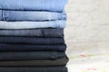 Degrade jeans folded on the bed. We used to have many clothes and wear a few of them Royalty Free Stock Photo