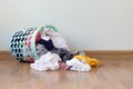 Pile of clothes overflow plastic laundry basket for washing preparations.