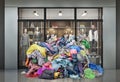 A pile of clothes pours out of an open clothing store.