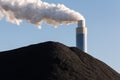 Pile of coal with the chimney of a coal power plant behind Royalty Free Stock Photo
