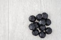 Pile of coal shaped candy on a gray washed wood background