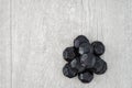 Pile of coal shaped candy on a gray washed wood background