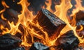 A pile of coal and a pile of wood are burning in a fire. The coal is burning yellow and orange, while the wood is burnin