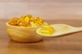 A pile of cod liver oil capsule in a wooden spoon.