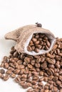 Pile of coffee beans and jute drawstring bag on the white background Royalty Free Stock Photo