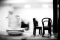 Pile of coffee cups with little chairs on the shelf in cafe.