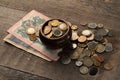 Pile of coins and banknotes on a wooden table Royalty Free Stock Photo