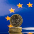 Pile of coins one euro against the background of the flag of the Royalty Free Stock Photo