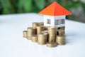 A pile of coins with an orange roof on top. Money saving concepts for buying a home or loan for real estate investment planning Royalty Free Stock Photo