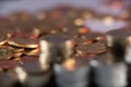 Pile of Coins out of focus and different coins in the background in Focus. Shallow depth of field