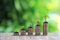 Pile of coins are stacked in a graph shape with trees growing for money saving Royalty Free Stock Photo