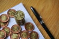 Pile of coins on the wooden table with a golden Czech Crown coin in the value of 20 CZK on the top