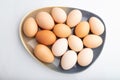 Pile of colored chicken eggs on plate isolated on white background. top view, close up