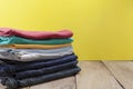 Pile of colored clothes on wood table yellow background Royalty Free Stock Photo