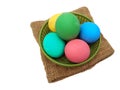 Pile of colorful century or potash preserved eggs in green plastic basket on brown sackcloth