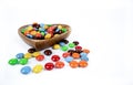 pile of colorful chocolate candies in wooden bowl on white background Royalty Free Stock Photo