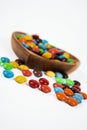 pile of colorful chocolate candies in wooden bowl on white background Royalty Free Stock Photo