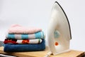 Pile of colorful clothes and electric iron Royalty Free Stock Photo