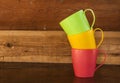 Pile of colorful cups on wooden table Royalty Free Stock Photo