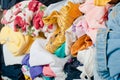 Pile of colorful messy clothes in closet. Untidy cluttered woman by side view.