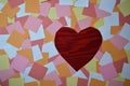 Pile of colorful notepads with red wooden heart