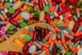 Pile of colorful pills and wood spoon. Medicine, vitamins, supplement and minerals. Antibiotics drug resistance and drug use