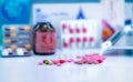 Pile of colorful tablets and capsules pills on blurred drug tray, bottle, and capsule in blister pack. Pharmacy shop background. Royalty Free Stock Photo