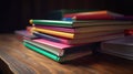 Pile of colorful textbooks on wooden desk