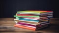 Pile of colorful textbooks on wooden desk