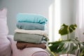 Pile of colorful warm clothes on the grey sofa