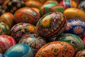 a pile of colorfully painted eggs sitting on top of each other on a tablecloth covered tablecloth with a black table cloth on it