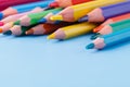 Pile of colour pencils on light blue background, creative idea c