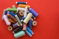 Pile of coloured bobbins of lurex thread on red background Royalty Free Stock Photo