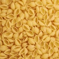 Pile of conchiglie yellow pasta as abstract background