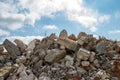 A pile of concrete fragments of a destroyed building against the blue sky