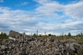 A pile of construction debris remains of a building on a vacant lot against the blue sky. Background