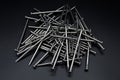 Pile of construction iron nails on a black isolated background