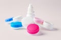 Pile of contact lens cases with white bottle on beige background