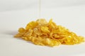 pile of corn flakes with dripping golden honey, isolated on white.