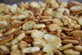 A pile of crackers, potato chips and sticks in a bowl